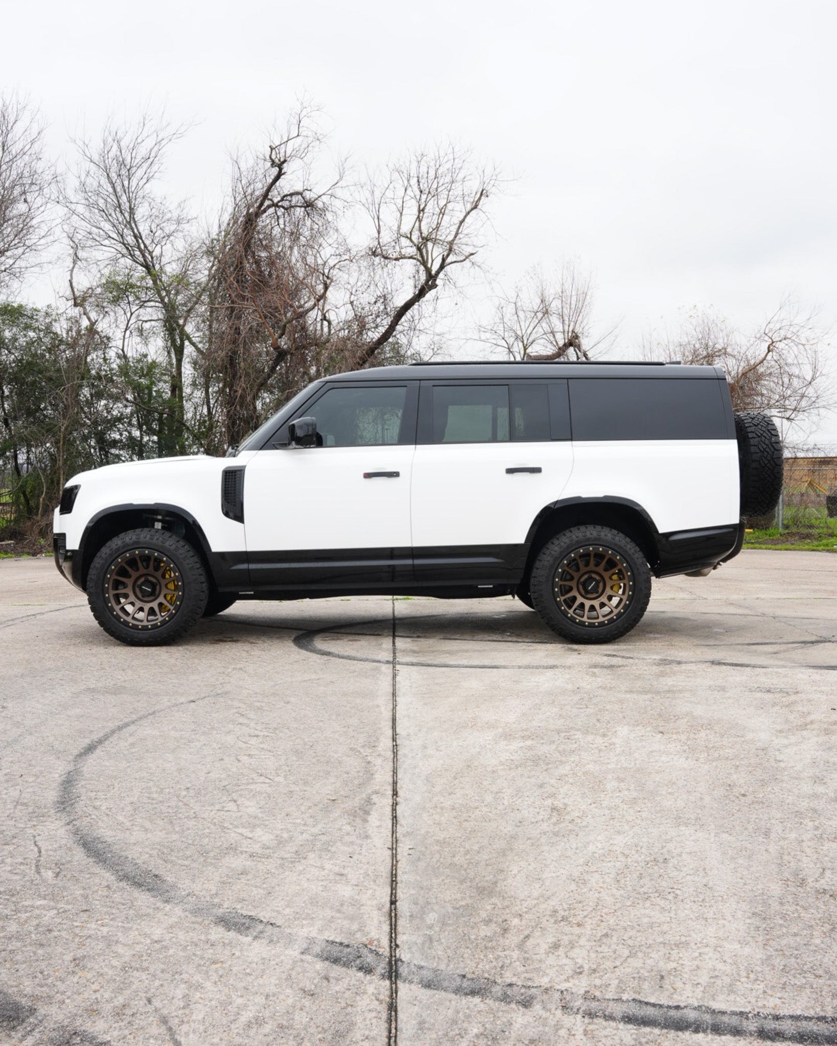Elevating the Land Rover Defender: White Wrap, Lift Kit, Wheel Upgrade & Custom Blackout Package